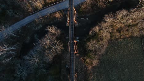 Aerial-Top-Down-Shot-of-the-Pope-Lick-Railroad-Trestle-and-the-Surrounding-Woods-and-Stream-During-Sunset-in-Louisville-Kentucky