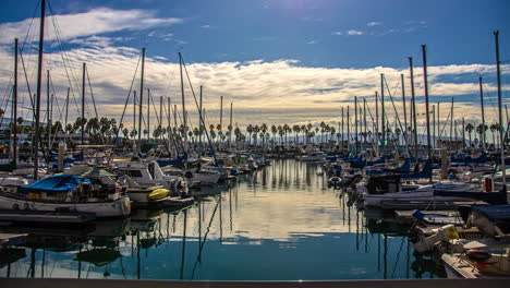 Sailboats-docked-at-a-yacht-club-with-the-cloudscape-sky-reflecting-off-the-water---time-lapse