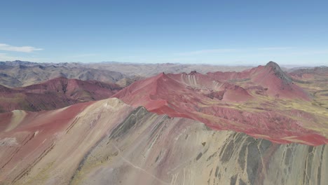 Drone-glides-forward,-showcasing-Rainbow-Mountain-in-the-enchanting-background-of-Red-Valley,-Peru