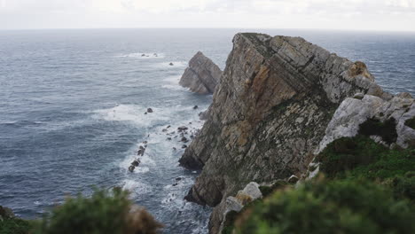 Scenic-seascape-in-Cabo-Peñas-cliffs-in-Asturias-Spain,-ocean-water-crashing-against-rock-formations-beach-coastline