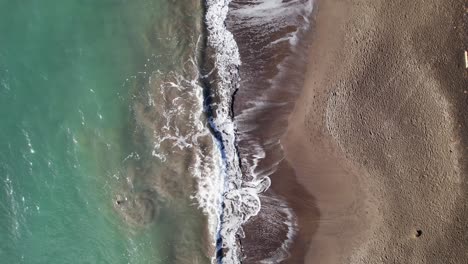 Beautiful-waves-flow-over-sandy-beach-of-Guadeloupe,-aerial-top-down-view