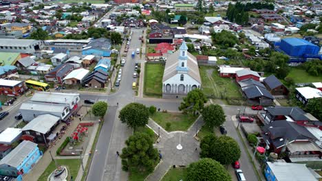 Aerial-view-toward-the-Patrimonial-church-of-Dalcahue,-cloudy-day-in-Chiloe,-Chile