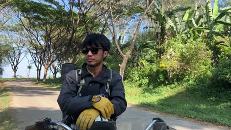 Tilt-Up-Shot-of-Biker-Take-A-Rest-on-Motorbike-While-Wearing-Sunglasses-at-The-Countryside-Road