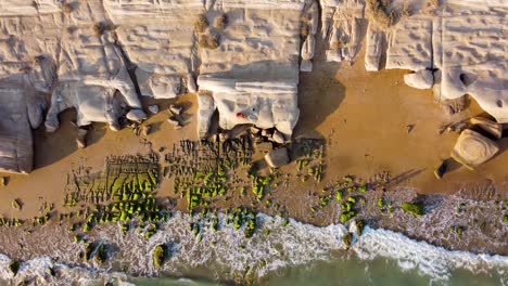green-algae-covered-wind-erosion-effect-on-rock-cliff-landform-in-seaside-beach-sea-landscape-of-wonderful-golden-sand-beach-the-tourist-attraction-resort-lodge-for-spa-wellness-health-in-Qatar-Iran
