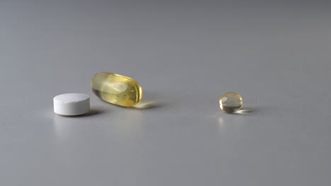Pillen-Unterschiedlicher-Farbe-Und-Form-Auf-Dem-Tisch,-Person-Nimmt-Weiße-Runde-Tablette