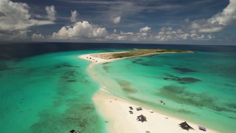 The-serene-los-roques-archipelago-in-venezuela,-showcasing-turquoise-waters-and-a-small,-sandy-islet,-aerial-view