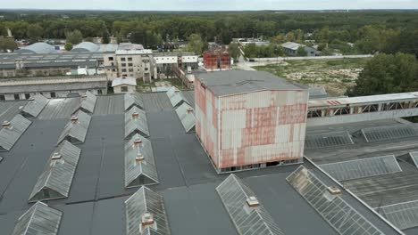 Aerial-shot-of-factory-complex-and-rooftop-with-glass-windows,-overcast-day