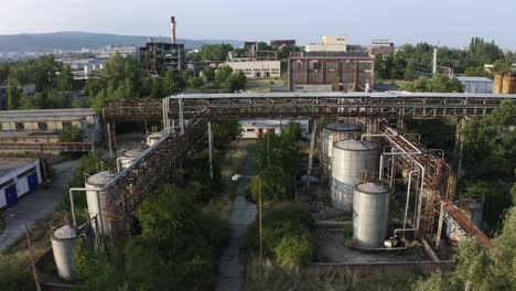 Aerial-view-of-old-pipeline-and-industrial-chemical-containers-in-abandoned-factory-area