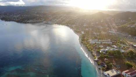 Sunset-on-a-tropical-beach-in-Grenada,-aerial-reveal