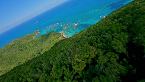 Drone-flying-over-tropical-forest-and-descending-towards-Playa-Ermitano-beach,-Samana-in-Dominican-Republic