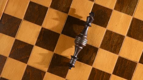Beaten-from-war,-chess-pieces-king-and-queen-laying-down-on-chessboard