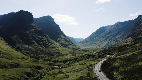 Drone-shot-of-cars-driving-through-the-Glencoe-Valley-in-Scotland