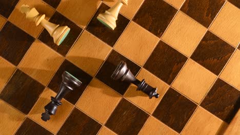 Black-and-white-kings-and-queens-knocked-down-on-chessboard