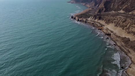 Fly-over-the-ocean-in-coastal-mountain-road-erosion-effect-on-hills-side-road-wonderful-natural-landscape-beautiful-nature-wonders-in-marine-adventure-yacht-club-in-middle-east-heavy-wave-boat-riding