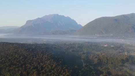 Aerial-View-Of-Morning-Fog-Over-Forest-Tops-In-Chiang-Dao