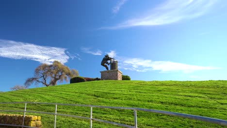 The-Napa-Valley,-The-Grape-Crusher-sculpture-push-back-on-wide-scenic-landmark