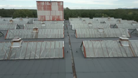 Schneller-Flug-Aus-Der-Luft-über-Das-Dach-Mit-Glasfenstern-Im-Fabrikkomplex