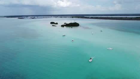 Barcos-Navegando-Por-Las-Cristalinas-Aguas-Azules-De-La-Laguna-De-Bacalar-En-México,-Vista-Aérea.