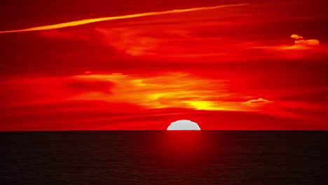 Round-sun-orb-in-vivid-red-sunset-sky-dips-below-horizon-over-ocean,-timelapse