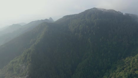 Aerial-view-of-incredible-mountainous-natural-landscape-and-rain-forest-in-slightly-foggy-weather