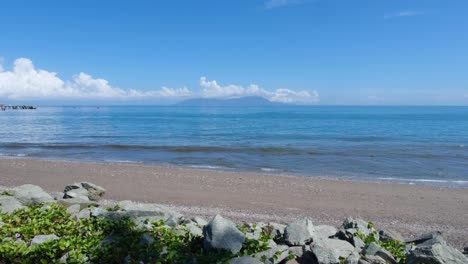 Malerische-Landschaftsansicht,-Tropisches-Blaues-Meerwasser-Und-Sandstrand-An-Einem-Sonnigen-Tag-In-Der-Hauptstadt-Dili-Mit-Blick-Auf-Das-Beliebte-Tourismus-Tauchziel-Der-Insel-Atauro-In-Timor-Leste