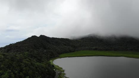 Aerial-reverse-ascend-above-Grand-Etang-national-park-lake-in-Grenada-on-cloudy-day