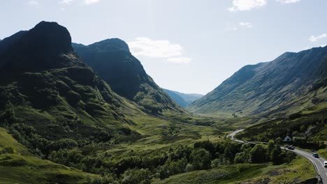 Aerial-shot-of-cars-passing-through-Scotland's-famous-Glencoe-Valley