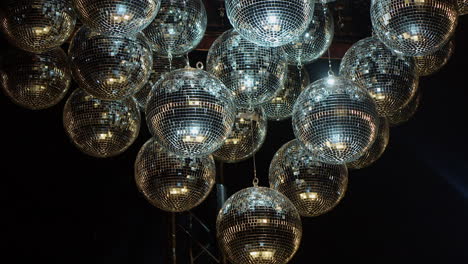 Silver-mirror-balls-shimmer-and-sparkle-in-darkness-as-light-reflects