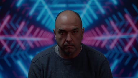 Middle-aged-white-male-looking-at-camera-with-a-blank-stare-look-with-a-moving-colorful-background