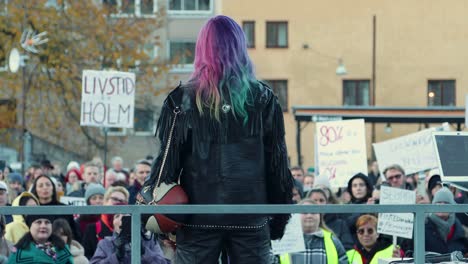 Aktivistin-Linnea-Claeson-Bei-Einer-Kundgebung-Für-Frauenrechte,-Vor-Einer-Menschenmenge-Mit-Protestschildern,-Städtisches-Umfeld