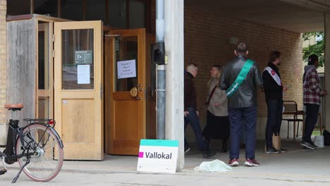 People-queuing-outside-a-polling-station-in-Stockholm-during-elections,-daytime,-democracy-in-action