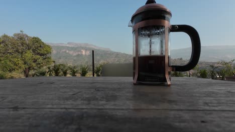 Coffee-Drinking-in-Scenery-with-French-Press,-Mountains,-Landscape-in-Background,-Black-Coffee,-Espresso-Coffee,-Holiday,-Air-BNB,-Vacation,-in-Garden-Coffeee