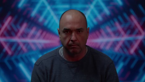 Middle-aged-white-male-looking-up-to-camera-with-a-menacing-look-with-a-moving-colorful-blue-background