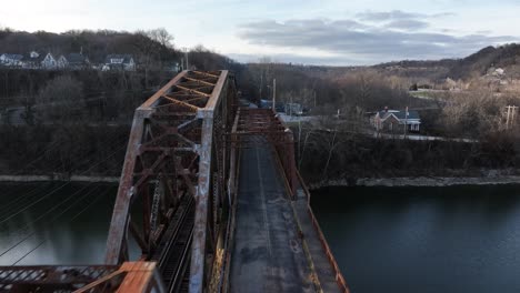 old-RJ-Corman-railroad-bridge-in-downtown-Frankfort-Kentucky-during-Sunset-with-a-sun-flare-AERIAL-DOLLY-PAN