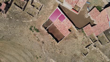 Brick-house-ruins-in-deserted-land-in-Spain-on-hot-sunny-day,-aerial-downwards-view