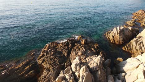 Felsen,-Die-Von-Wellen-Des-Blauen-Meeres-An-Der-Zerklüfteten-Costa-De-Blanes-In-Spanien-Umspült-Werden
