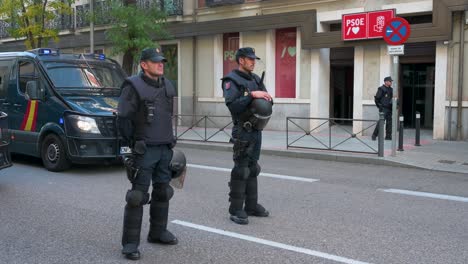 Police-officers-stand-on-guard-outside-the-PSOE-headquarters-office-as-protesters-gather-during-a-demonstration-against-the-PSOE-Socialist-party's-deal-with-Junts-per-Catalunya-and-grant-amnesty