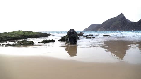Entspannende-Meereslandschaft-Mit-Blick-Auf-Den-Sandstrand-Mit-Inselchen,-Felsen,-Wellenschaum-Und-Reflexionen