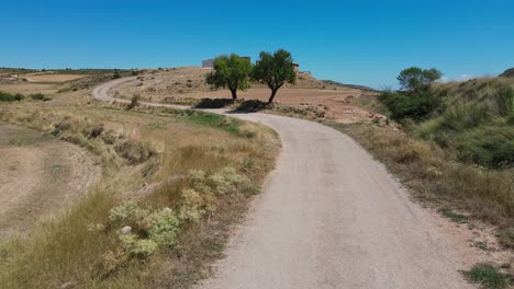 Dirt-road-arriving-at-ruined-buildings-in-Teruel,-Aragon