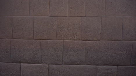 Eine-Asiatische-Touristin-Geht-Durch-Die-Mauern-Von-Qorikancha-In-Cusco,-Peru,-Die-Aus-Einheimischen-Steinen-Mit-Ihren-Komplizierten-Schnitten-Bestehen,-Die-Typisches-Mauerwerk-Der-Inkas-Sind