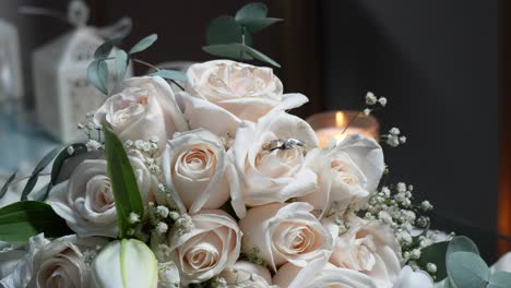 Wedding-rings-made-of-white-gold-among-the-white-rose-petals-of-the-bride's-bouquet