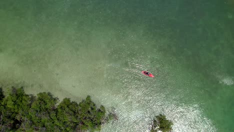 paddle-boarder-going-around-small-island-aerial-bird-eye-view