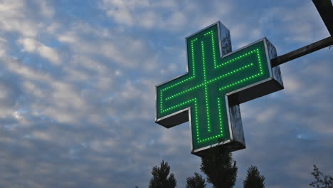 Illuminated-green-pharmacy-cross-in-front-of-the-drugstore