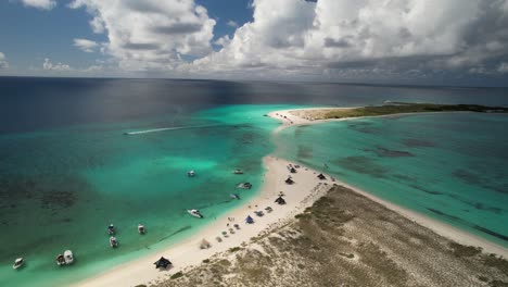 Los-roques-archipelago-showing-crystal-clear-waters,-sandy-beach,-and-boats,-aerial-view