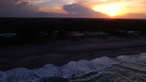 Sonnenuntergang-über-Dem-Strand,-Während-Wellen-In-Der-Seitlich-Scrollenden-Antenne-Rollen
