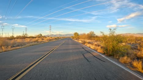 POV:-Conducción-Por-Una-Carretera-Asfaltada-Y-Bajo-Líneas-De-Transmisión-De-Energía-A-Través-Del-Desierto-De-Sonora-En-El-Sur-De-Arizona