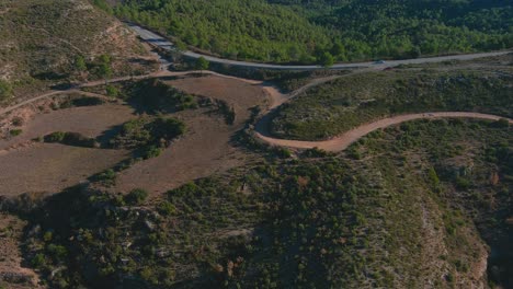 Aerial-view-of-road-next-to-forest-of-crosses,-near-Marganell,-Barcelona