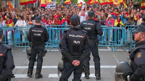 Polizisten-Stehen-Vor-Dem-Büro-Des-Psoe-Hauptquartiers-Auf-Der-Hut,-Während-Sich-Demonstranten-Während-Einer-Demonstration-Gegen-Den-Deal-Der-Psoe-Sozialistischen-Partei-Mit-Junts-Per-Catalunya-über-Die-Gewährung-Einer-Amnestie-Versammeln