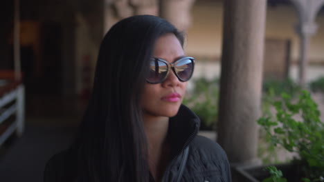 Asian-woman-with-sunglasses-during-winter-appreciating-the-view-of-the-Qorikancha-sacred-temple-in-Cusco-Peru