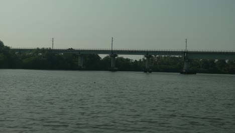 Eisenbahnbrücke-über-Ruhigen-Fluss,-üppiges-Grün-An-Ufern,-Ruhige-Umgebung,-Klarer-Tag